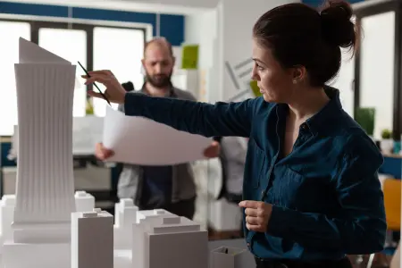 Architekten im Büro besprechen Baupläne für innovative Gebäude mit nachhaltigen Baumaterialien.